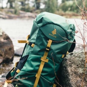 A green backpack rests on rocks in a scenic Canadian wilderness setting, perfect for outdoor enthusiasts.